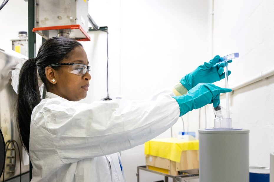 Researcher at ORNL lab wearing gloves, handling materials