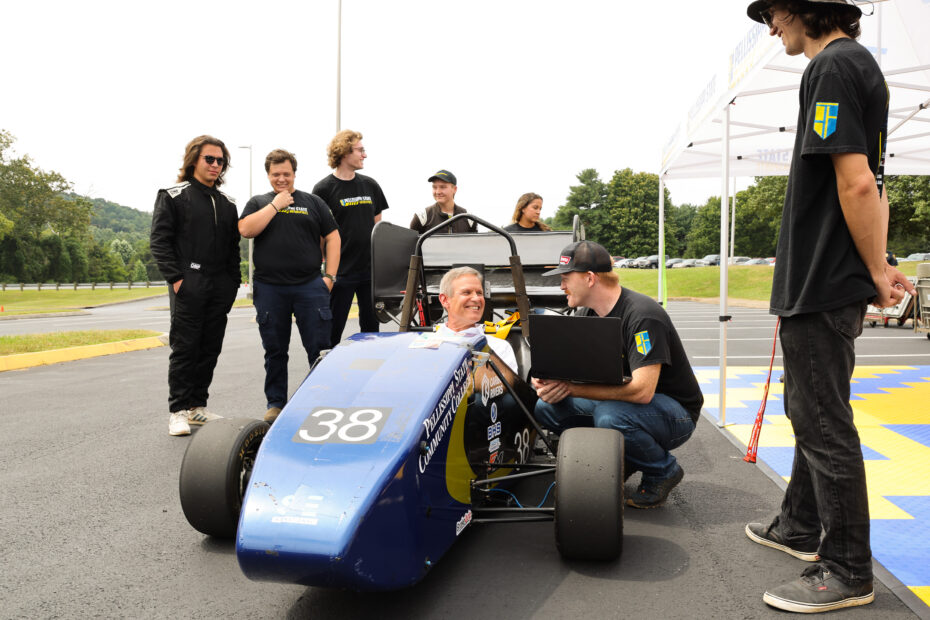Gov. Bill Lee, seated, learns about the race car Pellissippi States Motorsports students have designed, engineered and built.